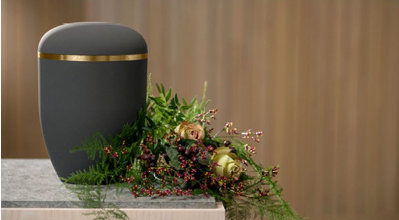 Mörk urna med mässingsrand och grönt